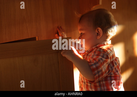 Einjähriger Junge Türöffnung Stockfoto