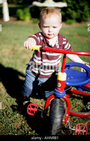 12 Monate alten Jungen drängen Dreirad Stockfoto