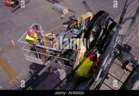 Männer, die aus einer mobilen Hebebühne Inspektion der Load-sensing-Ausrüstung an der Spitze der Ausleger eines Krans am Hafen. Stockfoto