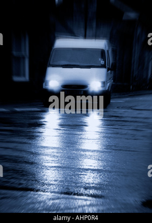 Van mit Lichtern auf dunklen nassen Straße Becccles Suffolk Stockfoto