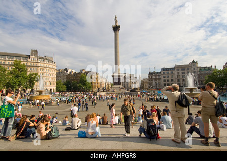 Touristen und Einheimische auf den Stufen der National Gallery an einem heißen Sommertag mit Blick auf dem Trafalgar Square. Stockfoto