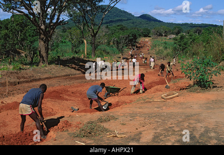 Gemeindearbeiter bauen nach dem Bürgerkrieg per Hand eine beschädigte Straße wieder auf. Zambezia, Mosambik Stockfoto