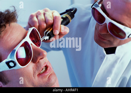 Mann mit Laser-Haarentfernung Stockfoto