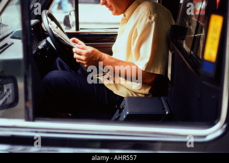 Taxifahrer, die Zeitung lesen Stockfoto