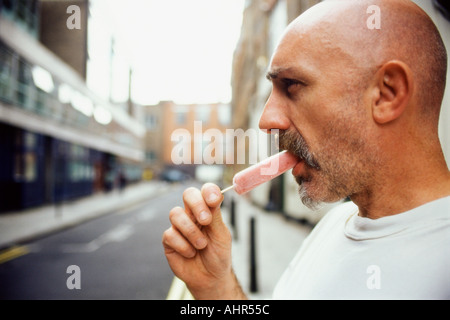 Mann isst ein Eis am Stiel Stockfoto