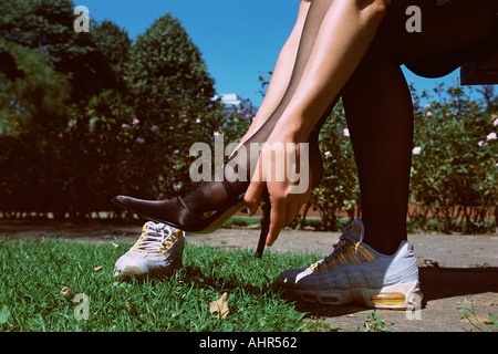 Frau ändern Schuhe im park Stockfoto