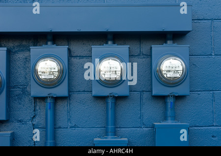 Drei elektrische Stromzähler und blaue Wand Stockfoto