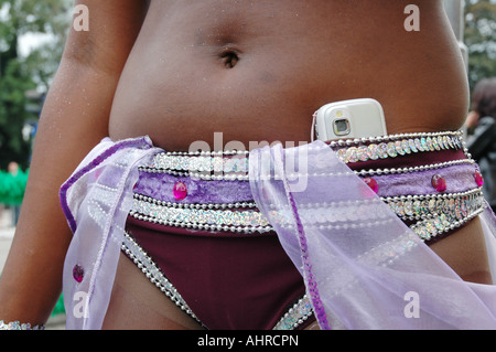 Frau im tropischen Karneval Bikini mit Handy Stockfoto