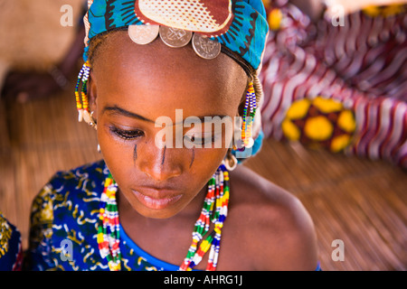 Alter von Unschuld - gekleidet in ihrem hellsten, feinste Kleidung, dieses Mädchen macht sich bereit zu gehen auf Markt, Obst zu verkaufen. Stockfoto