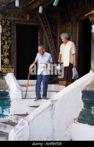 Ältere Buddhisten verlassen Seiteneingang die SIM-Karte von Wat Xieng Thong Tempel in Luang Prabang Laos Stockfoto