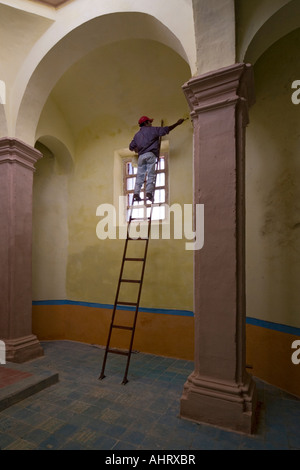 Ein Maler, hoch oben auf einer Leiter in einer Kirche (Mexiko). Peintre de Bâtiment Perché Sur Une Échelle Dans Une Église (Mexiko). Stockfoto