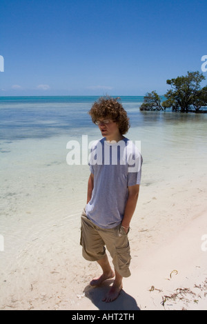 Teenager mit langen lockigen Haaren stehen in kurzen Hosen an einem Strand auf den Florida Keys Stockfoto