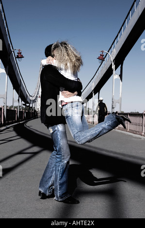 Junger Mann und eine Frau drehte sich um auf der Fussgängerbrücke romantische junges Paar Stockfoto