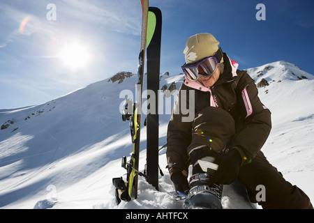 Reife Skifahrerin Befestigung Boot Bindungen am Berg Stockfoto