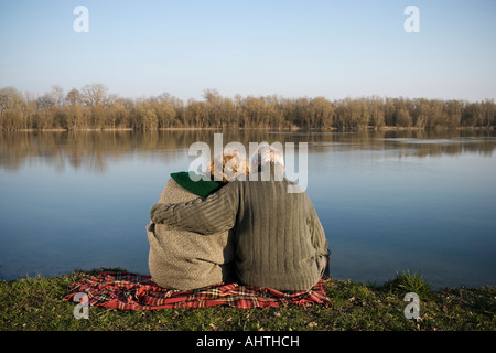 Älteres paar sitzen auf Teppich von Fluss, Rückansicht Stockfoto