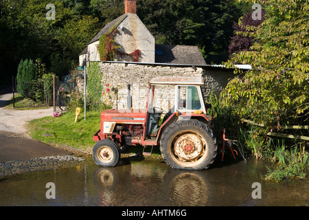 Ein Traktor zum Pumpwasser von Ford in Cotswold Dorf des mittleren Duntisbourne, Gloucestershire Stockfoto