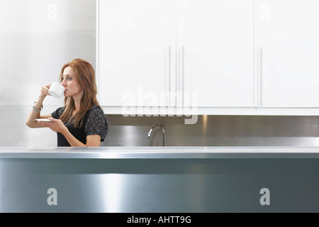 Frau trinkt Kaffee in Personal Küche Stockfoto
