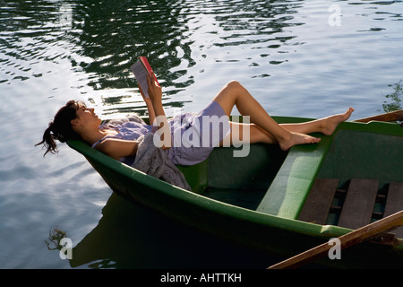 Frau liest ein Buch im Boot Stockfoto