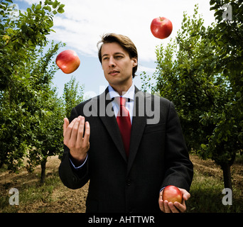 Mann Jonglage Äpfel im Obstgarten. Stockfoto