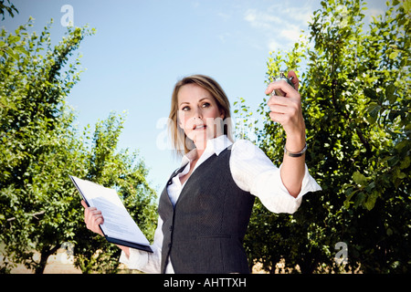Frau mit Stoppuhr im Obstgarten. Stockfoto