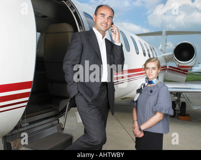 Geschäftsmann Privatjet neben Flugbegleiterin zu beenden. Stockfoto