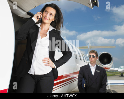 Geschäftsfrau außerhalb Jet vor Piloten. Stockfoto