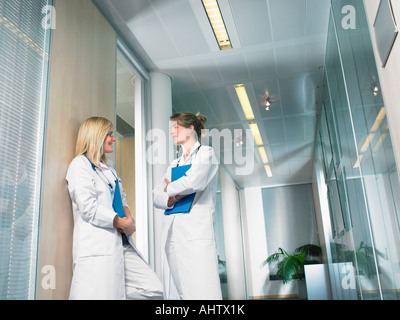 Zwei Ärztinnen im Gespräch in der Lobby eines Krankenhauses. Stockfoto
