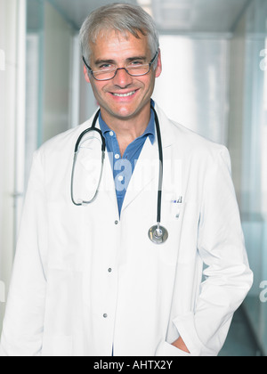 Porträt von Reifen männlichen Arzt in einer Lobby eines Krankenhauses. Schließen Sie lächelnd. Stockfoto