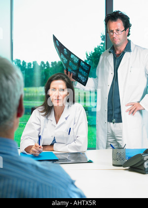 Zwei Ärzte Röntgen mit mündige Patient zu diskutieren. Stockfoto