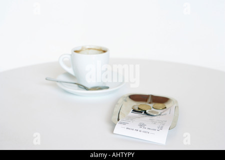 Espresso Tasse leeren und mit Wechsel in eine Untertasse in Rechnung. Stockfoto