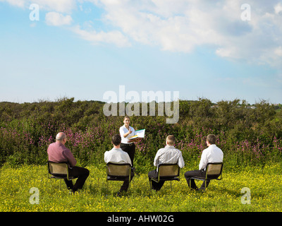 Gruppe von Geschäftsleuten, die sitzen auf Stühlen im Feld. Stockfoto