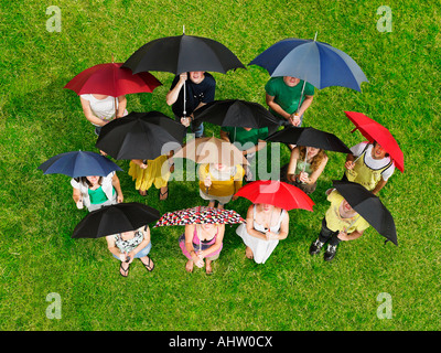 Gruppe von Menschen auf dem Rasen halten Sonnenschirme Stockfoto