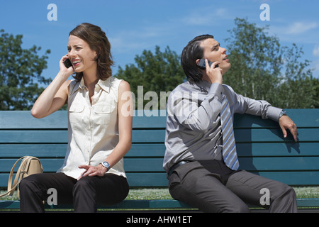 Geschäftsmann und Frauen reden auf dem Handy beim Sitzen auf der Bank vor. Stockfoto