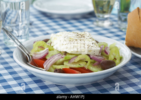 Griechischer Salat am Tisch Gläser und Teller im Hintergrund. Stockfoto