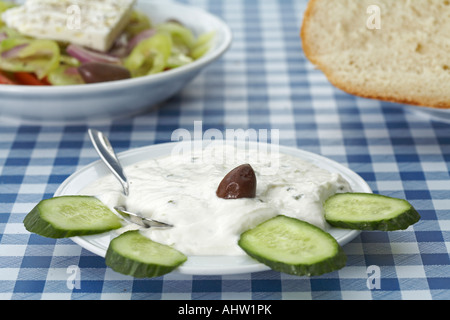 Griechischen Tsatsiki-Salat mit Gurke auf Tabelle griechischer Salat und Brot im Hintergrund dekoriert Stockfoto