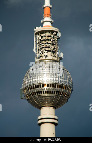 Vertikale Nahaufnahme des Fernsehturms "Fernsehturm" gegen dunkle graue Gewitterwolken. Stockfoto