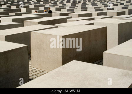 Horizontale Ansicht mehrere Touristen zu Fuß durch das Holocaust-Mahnmal, auch bekannt als Denkmal für die ermordeten Juden, an einem sonnigen Tag. Stockfoto