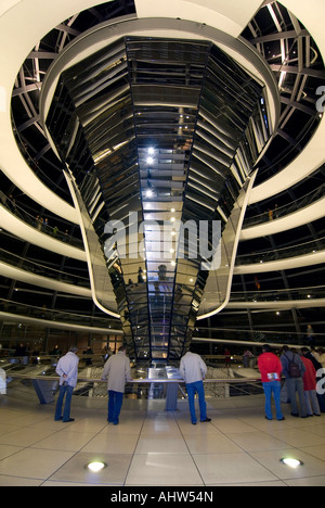 Vertikale Weitwinkel von Touristen in Sir Norman Foster Glaskuppel auf dem Dach des Reichstags, nachts beleuchtet. Stockfoto