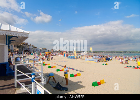 Horizontal wide angle of a typical English beach scene with lots of tourists on the sand at Weymouth Bay. Stockfoto