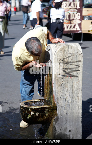Mann unter einigen Trinkwasser aus einer der vielen Straße Brunnen Lazio Rom Italien Stockfoto