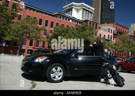 Der Managerin steht neben seinem Auto und ruft mit einem Laptop das Handy an, auf der Straße der Stadt Bilder horizontal in den USA hochauflösende Bilder Stockfoto