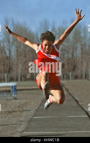 Schwarze weibliche Weitspringer konkurrieren in einem Gymnasium Track meet Stockfoto