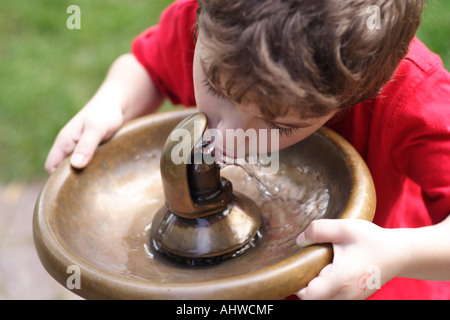 Boy ist Trinkwasser aus dem Trinkwasser-Brunnen Stockfoto