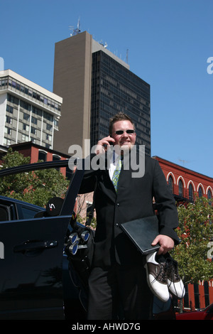 Der amerikanische junge Geschäftsmann spricht ein Mobiltelefon, der in der Stadt unterwegs ist, das Straßentelefon Bilder mit sehr hoher Auflösung vertikal in den USA hochauflösende Bilder in den USA hochauflösende Bilder Stockfoto