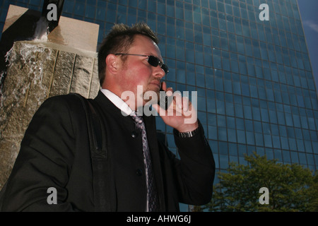 Der Managerin steht und ruft das Handy an, auf den Straßenbildern der Stadt horizontal in den USA hochauflösende Bilder Stockfoto