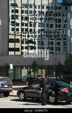 Amerikanischer junger Geschäftsmann Geschäftsmann mit Laptop, der auf der Straße vor dem Bürogebäude in den USA hoch aufgebrochen ist Stockfoto