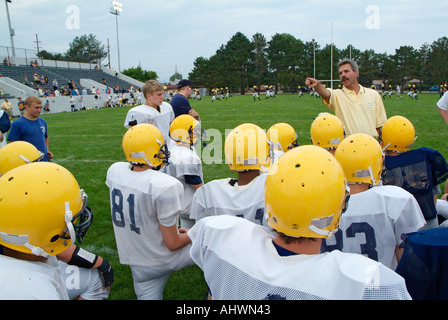 High School Football-Trainer geben aufmunternde Worte für die Spieler vor dem Training Stockfoto