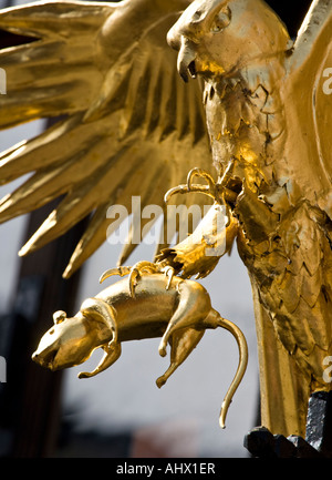 Diese golden Hawk und Ratte Skulptur sitzt oben auf ein Wegweiser in Edinburgh High Street, Royal Mile, Schottland. Stockfoto