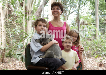 Kleiner junge Kind hält ein Koalabär in Lone Pine Koala Sanctuary Wildlife reserve Zoo Brisbane Queensland QLD Australien NAOH Stockfoto