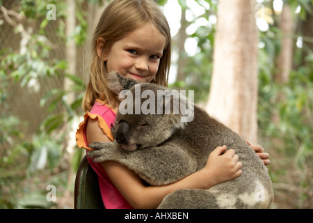 Junges Mädchen Kind hält ein Koalabär in Lone Pine Koala Sanctuary Wildlife reserve Zoo Brisbane Queensland QLD Australien OD Stockfoto